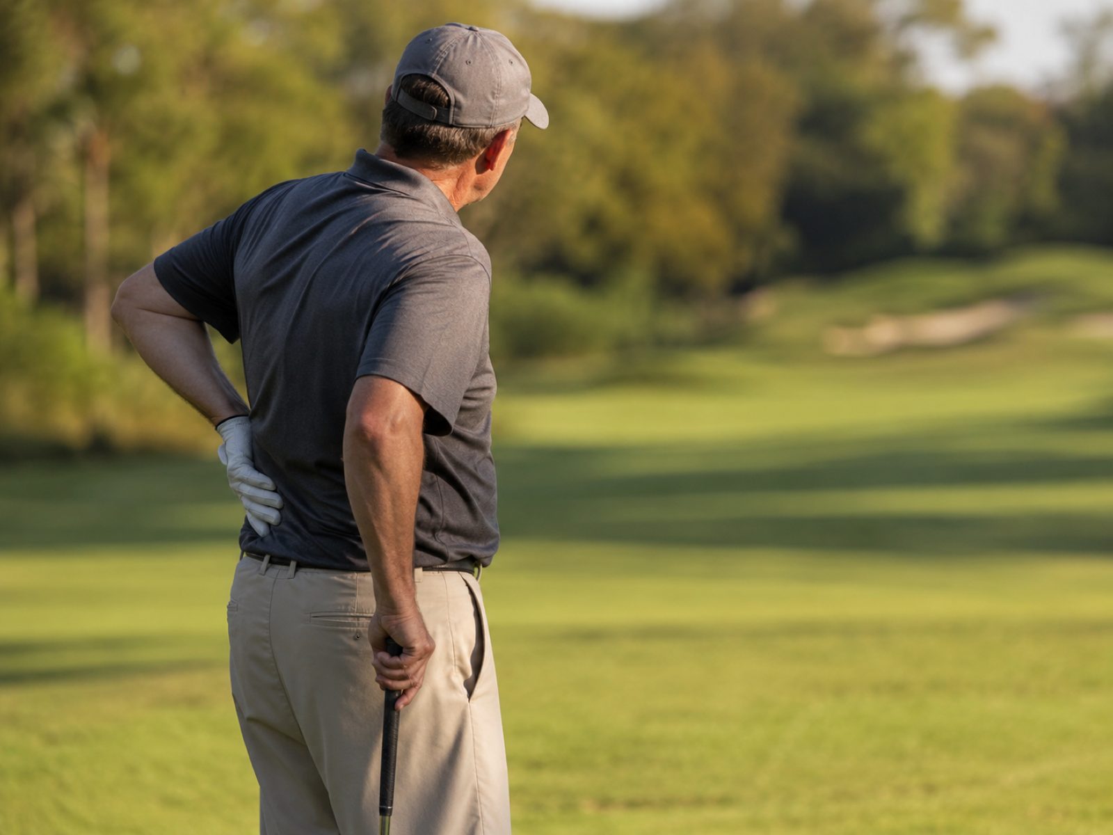 Fort Worth golfer holding his lower back in pain on the course