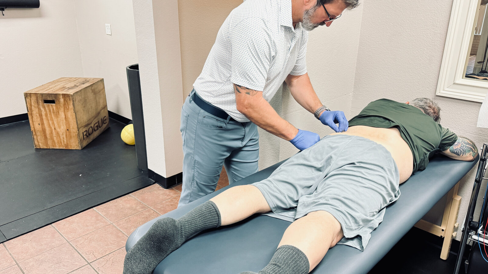 Dr. Jeremy Taylor performing hands-on manual therapy on a patient at his Fort Worth sports chiropractic clinic
