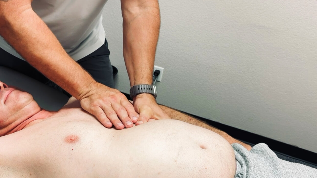 Fort Worth sports chiropractor performing hands-on myofascial soft-tissue therapy on a patient