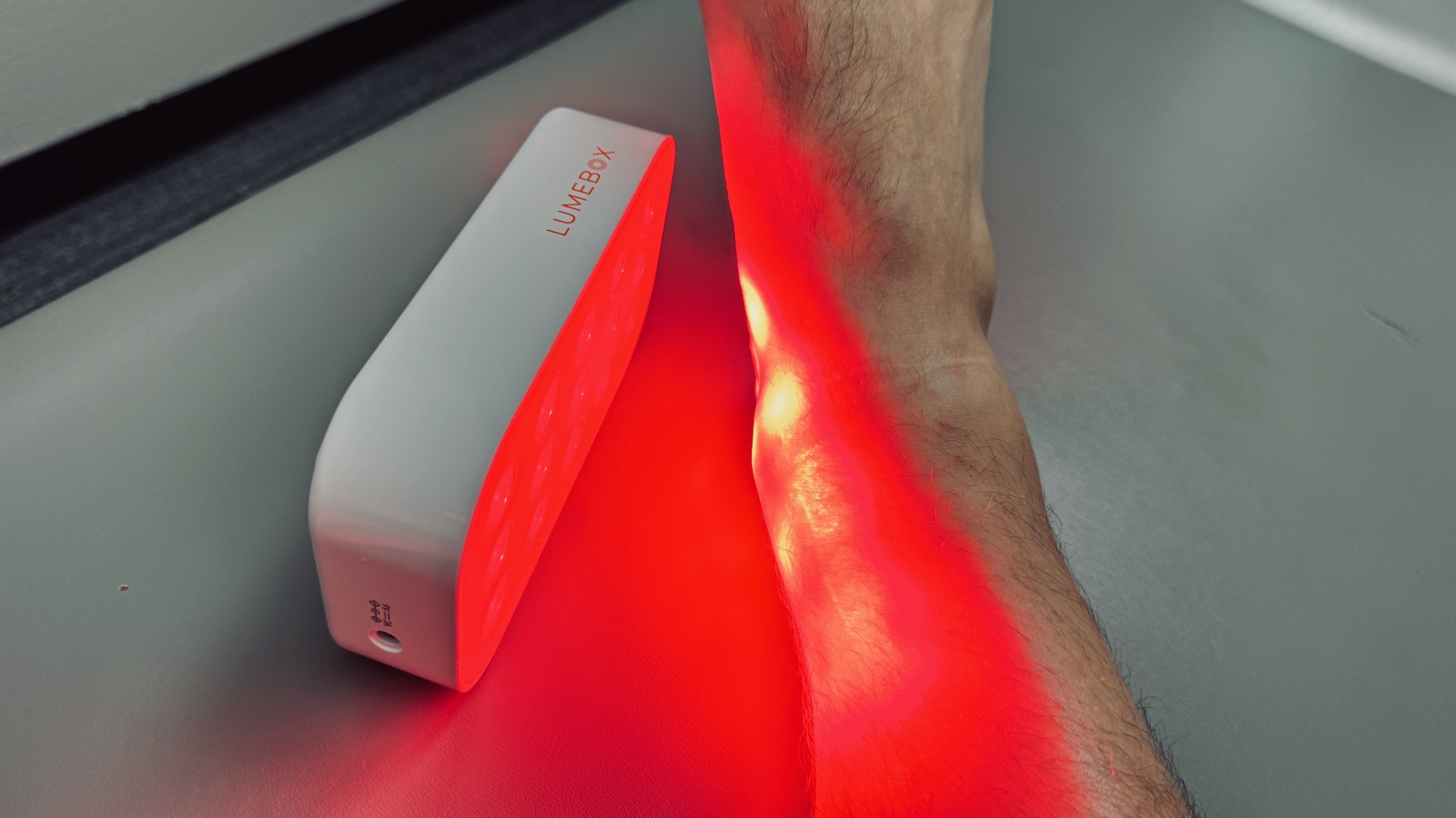 Red light therapy applied to an athlete's ankle for recovery at Taylor Made Integrative Therapy in Fort Worth